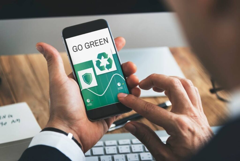 A person holding a smartphone displaying a go green app with eco-friendly icons and statistics, emphasizing sustainability efforts.