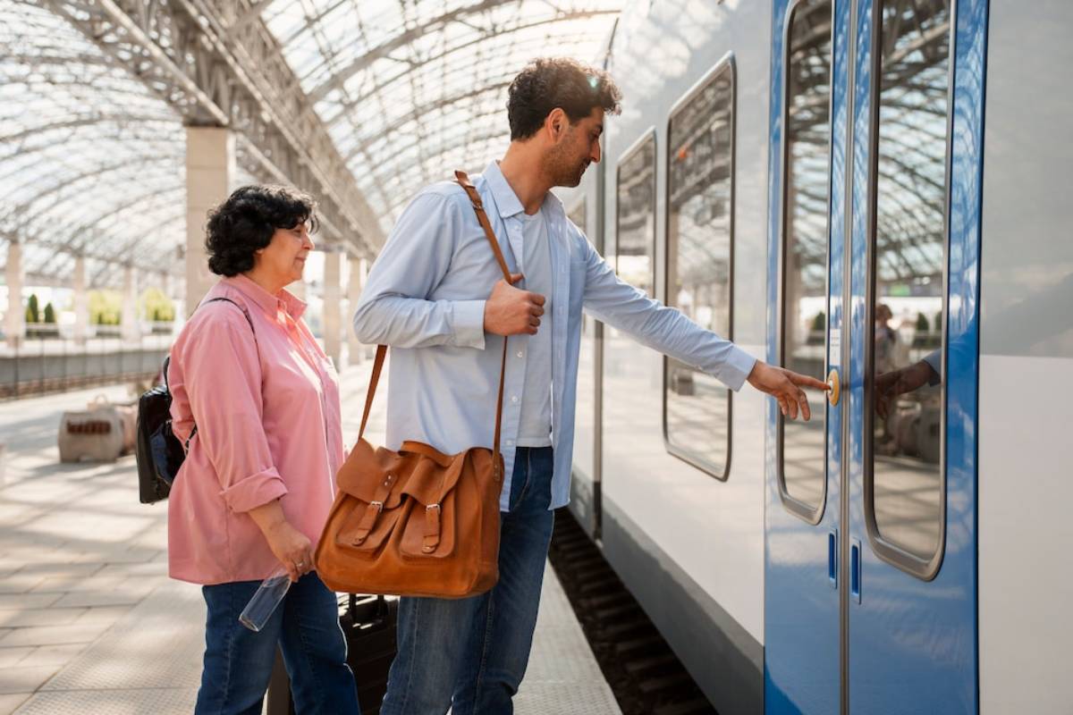A man reaching for the door handle of a train while a woman stands nearby, both in a spacious, modern train station. 
